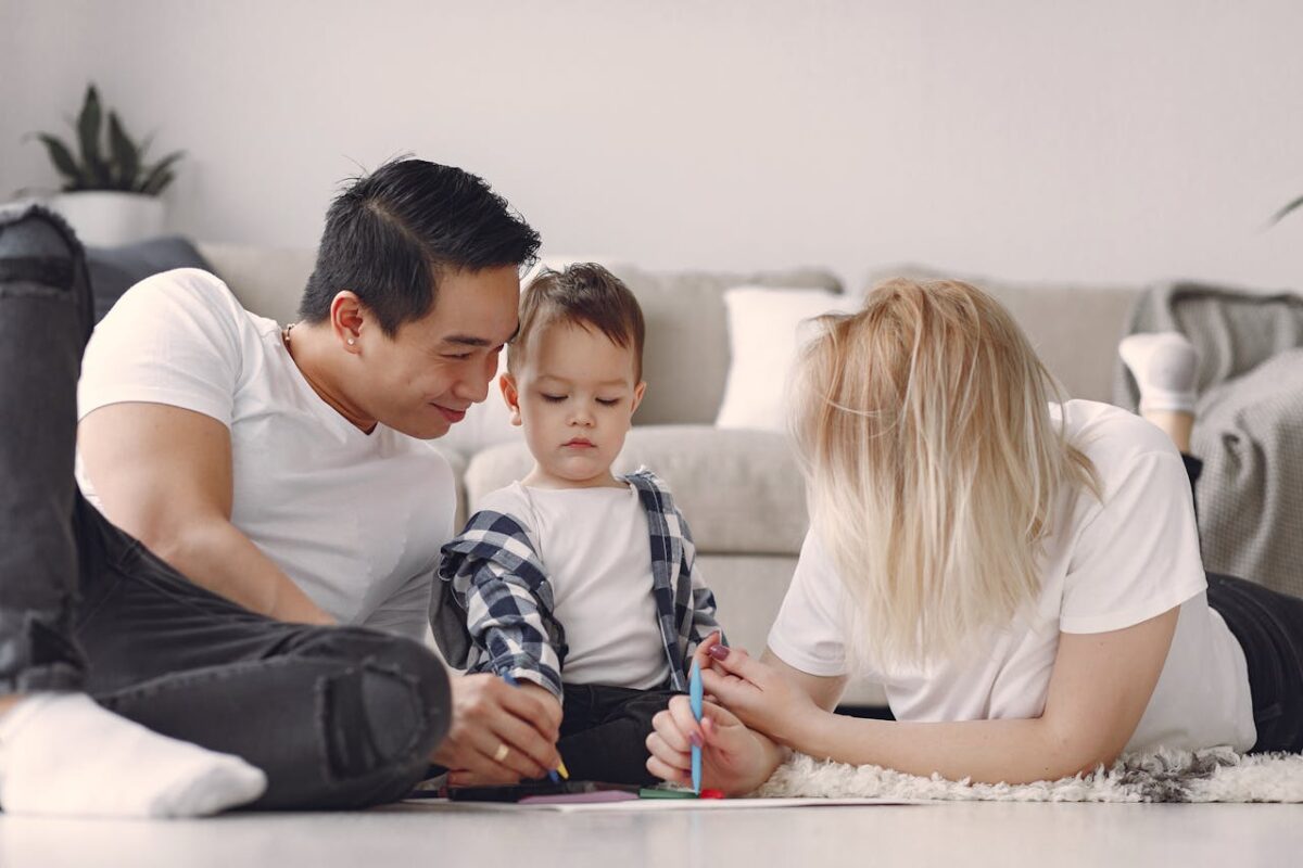 Family enjoying quality time drawing together on the living room floor.